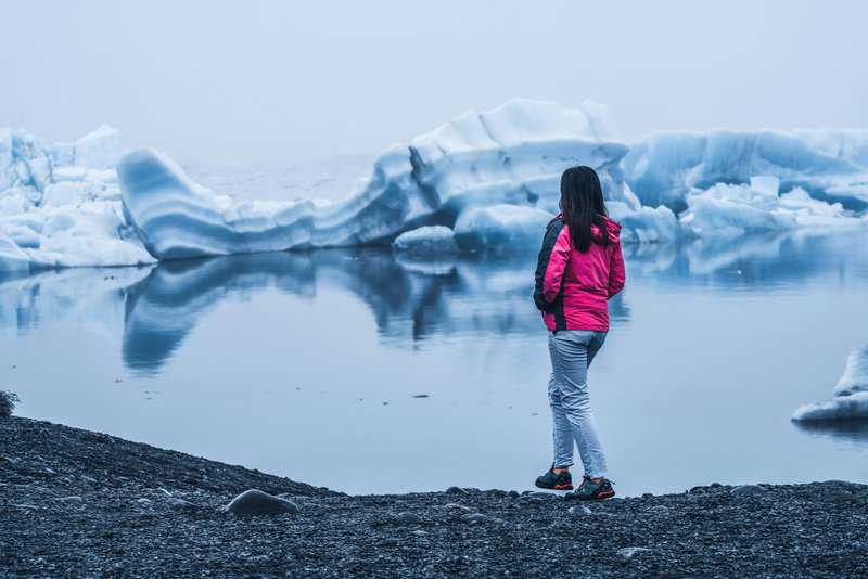 The Ultimate 9 Day Iceland Itinerary with Kids: Ring Road Route 1 6 Woman in Jökulsárlón Lagoon Iceland - Iceland Glaciers Tour - 9 Day Iceland Itinerary with Kids
